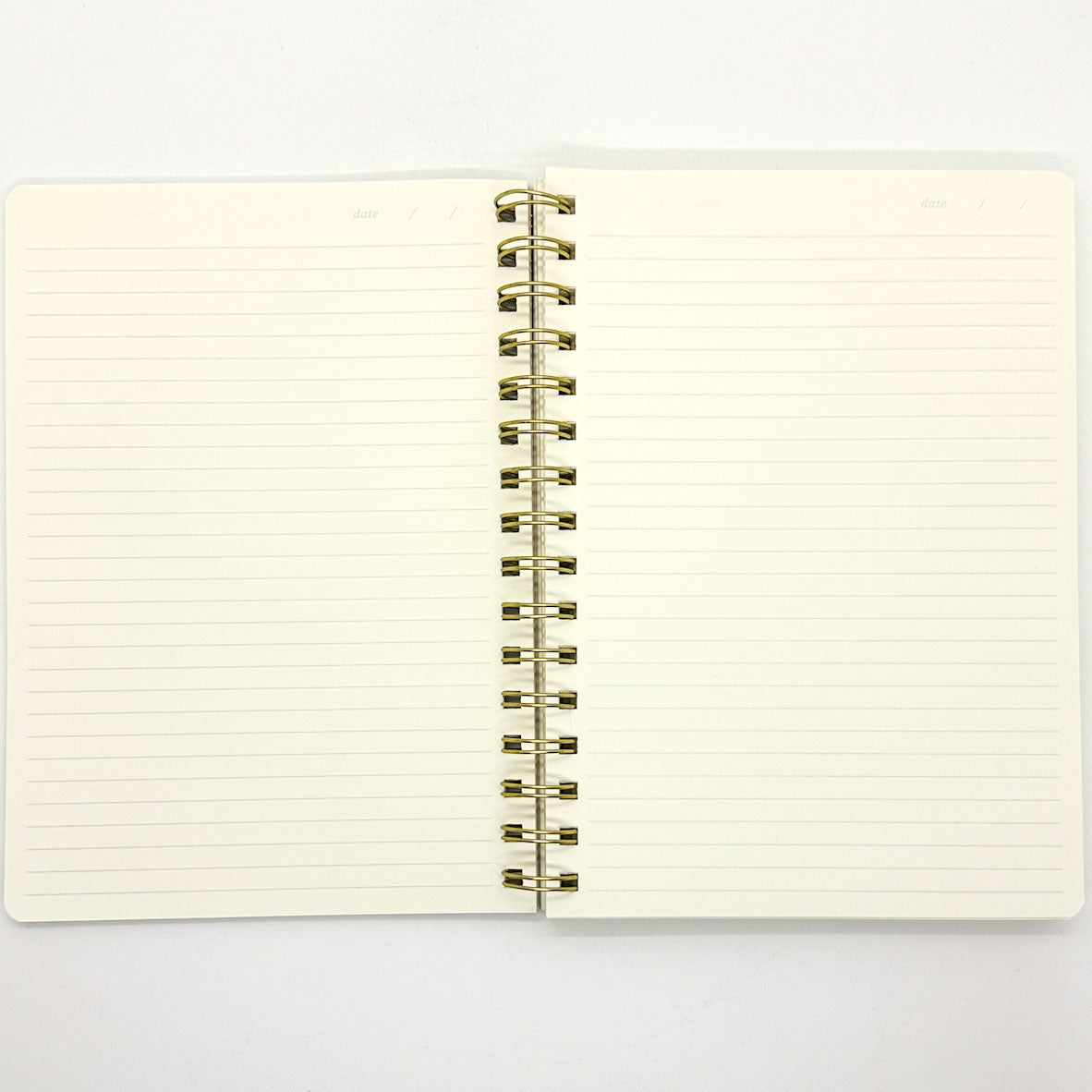 Open notebook with lined pages and gold spiral binding on a white background