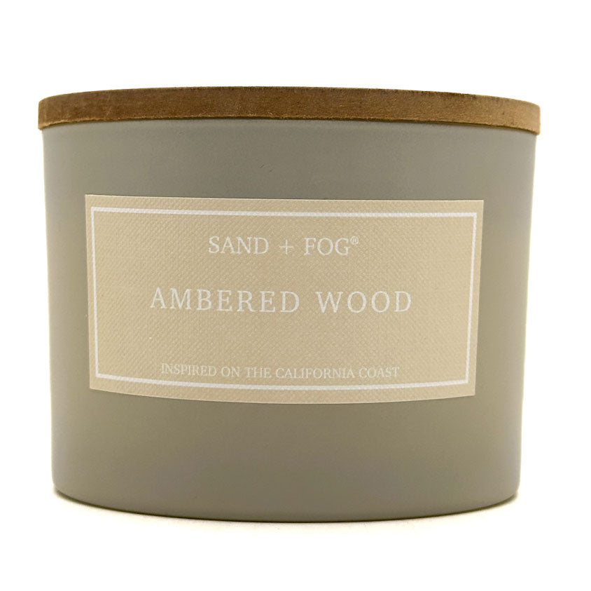 Ambered Wood Candle with 'Sand + Fog' label on a white background
