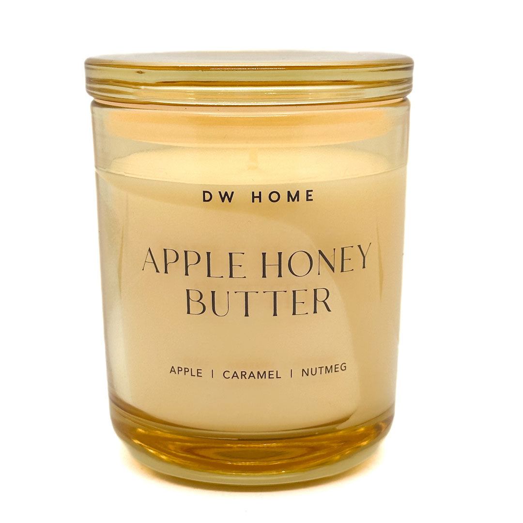 DW Home Apple Honey Butter candle in a clear glass jar with a gold lid on a white background