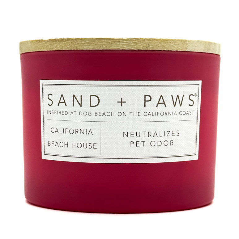 California Beach House red candle with 'Sand + Paws' label on a white background
