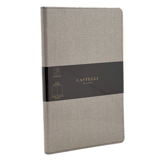 A grey herringbone-patterned hardcover notebook with a black paper band around the middle. The band features the brand name 'CASTELLI MILANO' in gold lettering, along with a small 'PROMOTION' label.