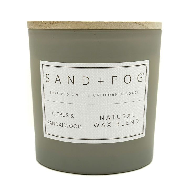 Citrus & Sandalwood scented candle with 'Sand + Fog' label on a white background