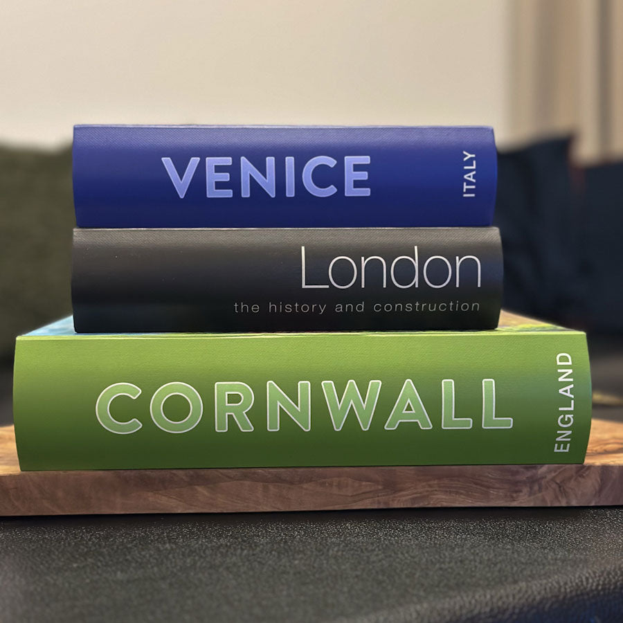Three keepsake book box titled 'Venice', 'London', and 'Cornwall' stacked on a wooden surface.