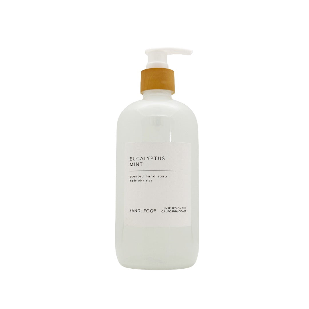 A frosted white pump bottle of Sand+Fog Eucalyptus Mint scented hand soap on a solid white background.