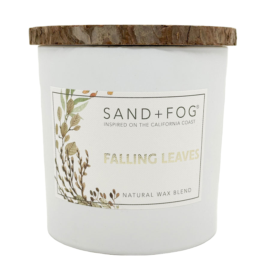 Candle with 'Sand + Fog' label and 'Falling Leaves' description on a white background