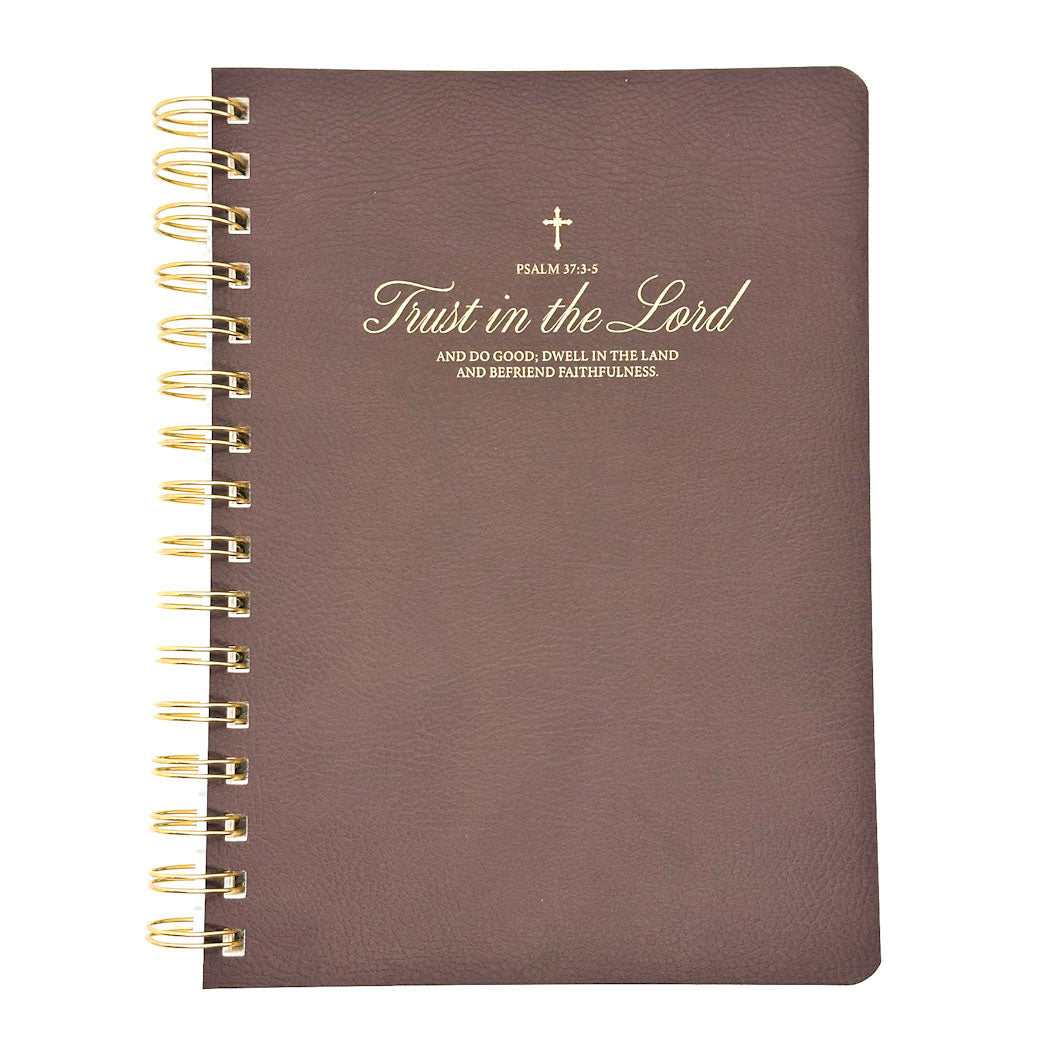 Brown notebook with gold spiral binding and psalm 37 text on a white background