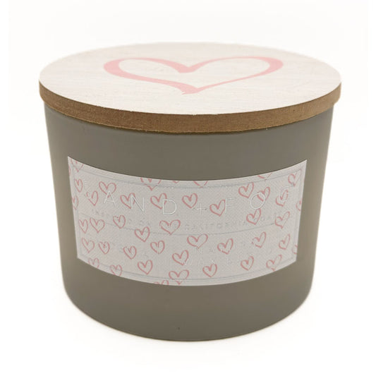 Gardenia cylindrical candle with a heart design on the lid and label, on a white background