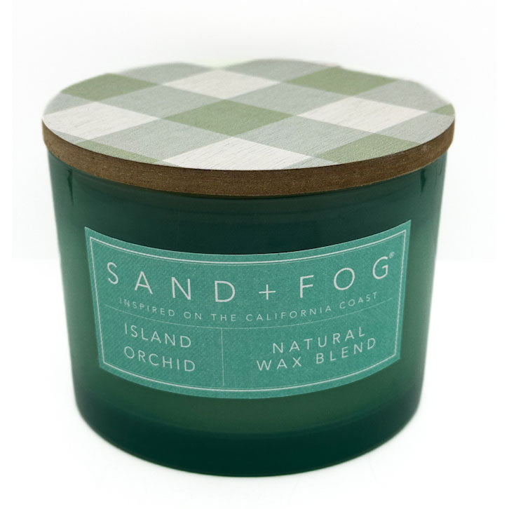 Island Orchid green candle with a checkered lid labeled 'Sand + Fog' on a white background