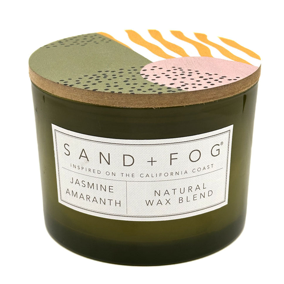 Jasmine Amaranth candle with a decorative lid featuring abstract patterns and 'Sand + Fog' branding.
