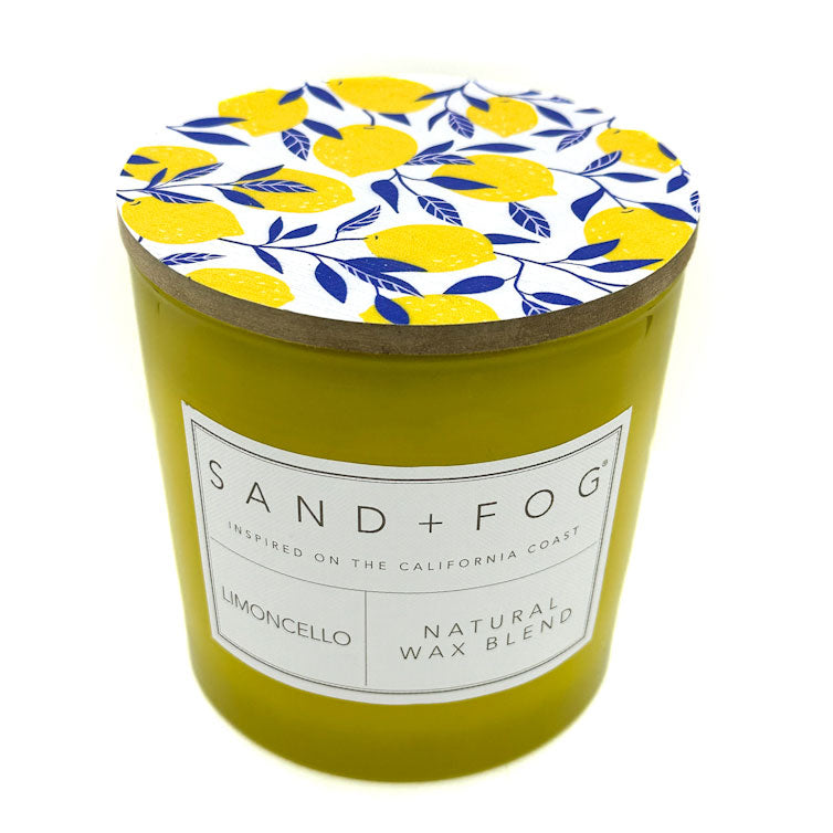 Limoncello Candle with a decorative lid featuring lemons and leaves, branded 'Sand + Fog'.