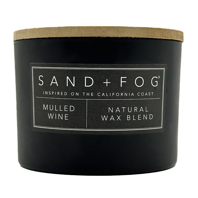 Mulled wine black candle with a wooden lid labeled 'Sand + Fog' on a white background