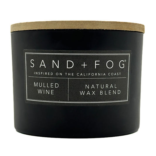 Mulled wine black candle with a wooden lid labeled 'Sand + Fog' on a white background