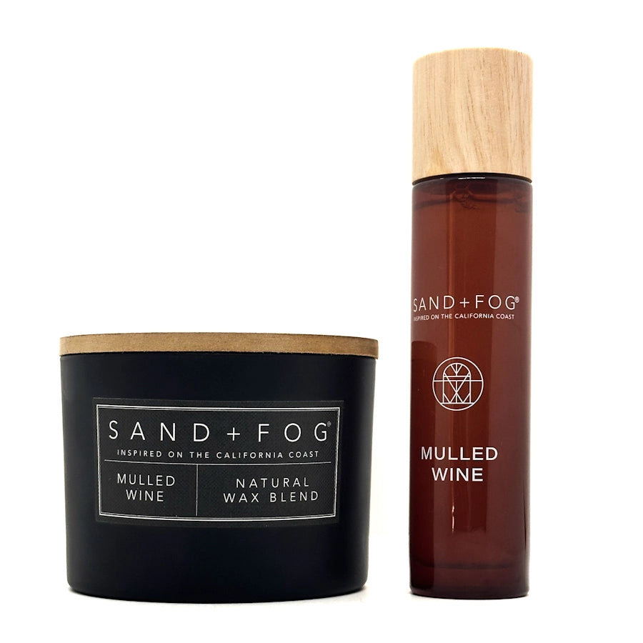 Candle and bottle of 'Mulled Wine' by Sand + Fog on a white background