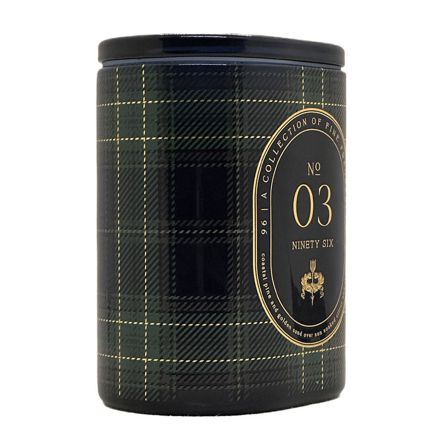 A cylindrical candle with a black and dark green plaid pattern and a gold circular label reading 'No 03 Ninety Six' and 'A Collection of Scents'.