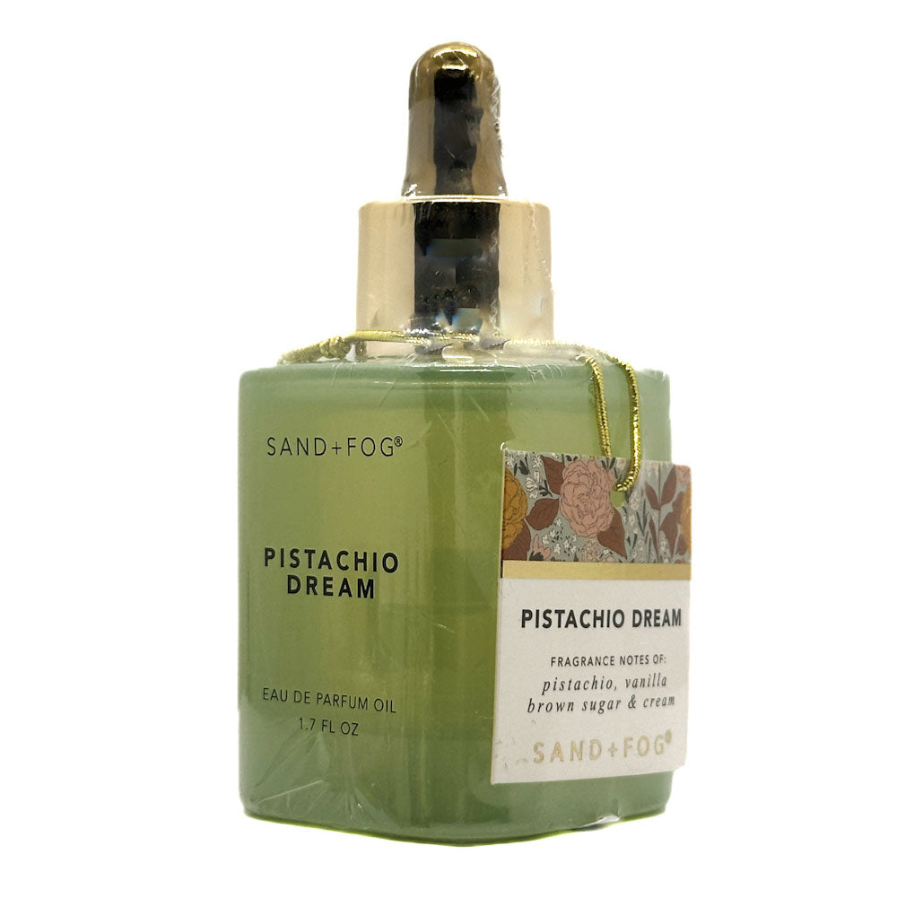 Green Perfume Oil bottle with gold oil dropper cap labeled 'Pistachio Dream' by Sand + Fog on a white background.
