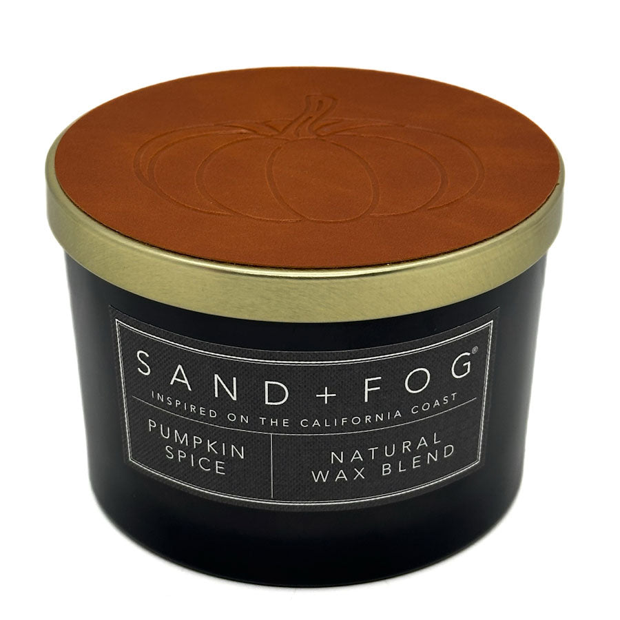 Pumpkin Spice black candle with a brown lid featuring Sand + Fog branding on a white background