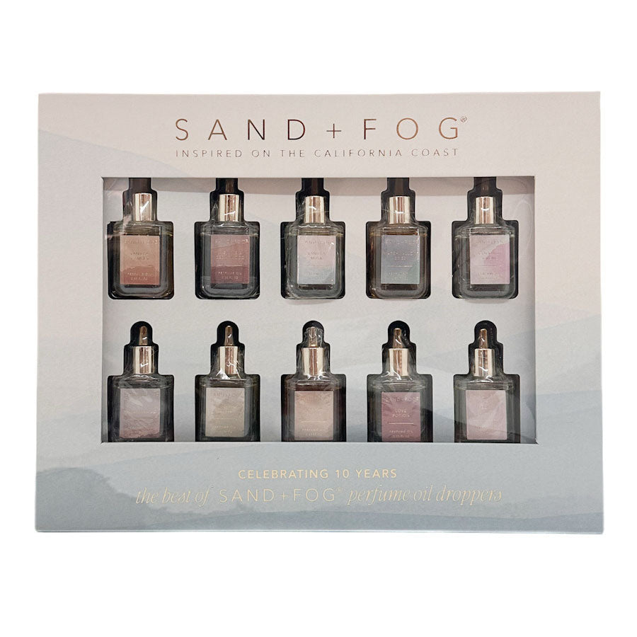 Sand + Fog Oil Drops gift set in its original packaging, featuring ten small glass dropper bottles with shimmering neutral and pinkish-gold oils, displayed on a clean white background.