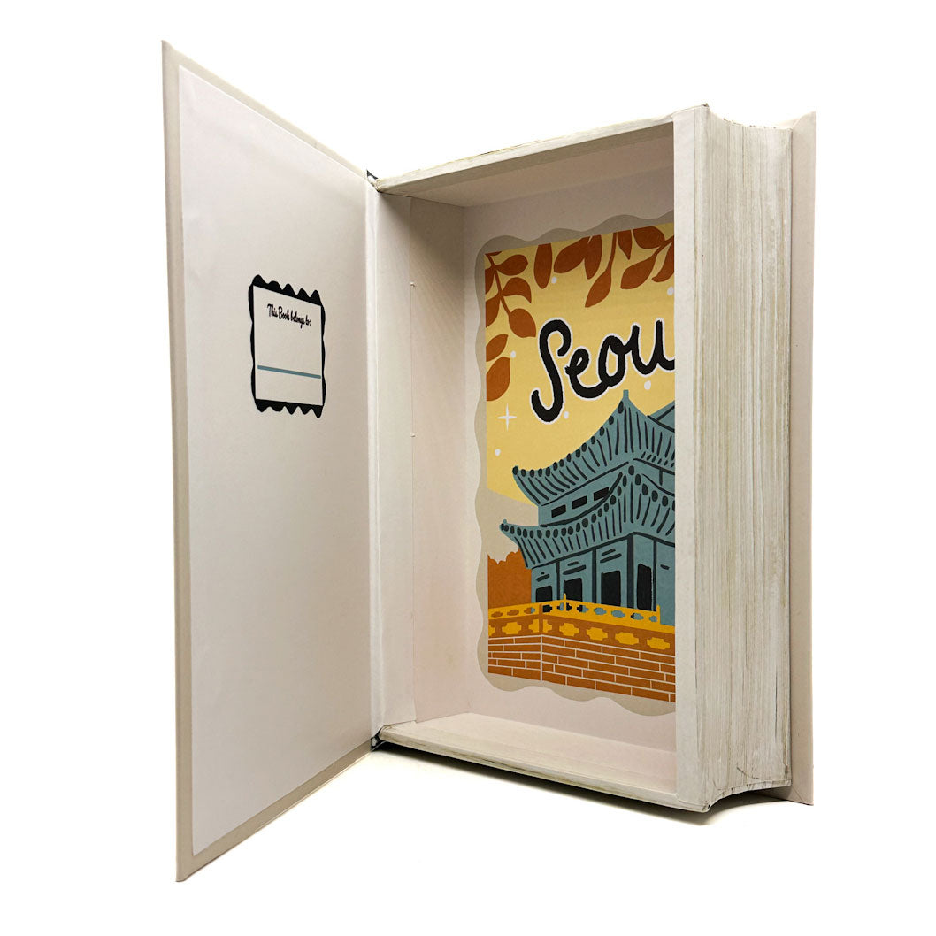 Open book with a decorative page featuring a traditional building and the word 'Seoul'.