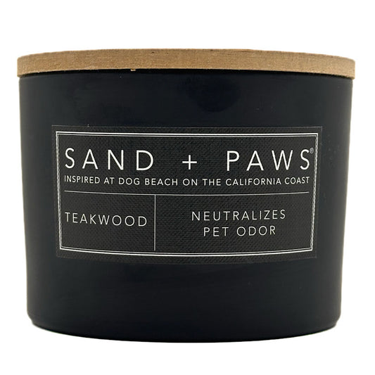 Teakwood Black candle with a wooden lid labeled 'Sand + Paws' on a white background