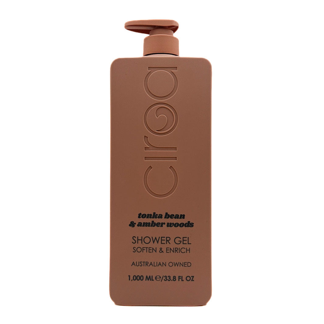 A 1000 mL bottle of Ciroa shower gel in the 'tonka bean & amber woods' scent. The bottle is a matte, warm brown colour with a matching brown pump dispenser on top.