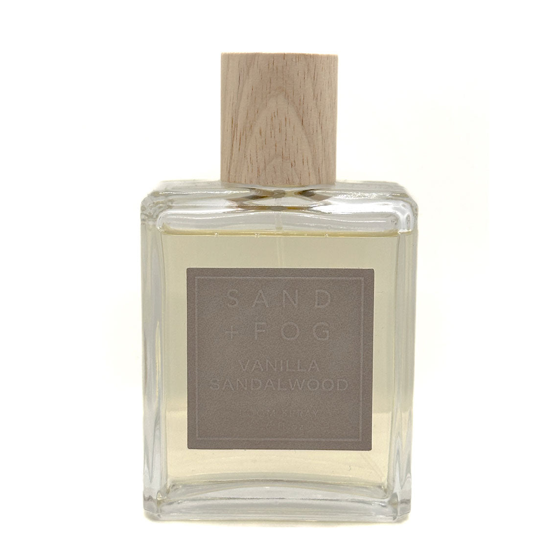 SAND + FOG Clear glass Vanilla Sandalwood room spray bottle with wooden top on a white background