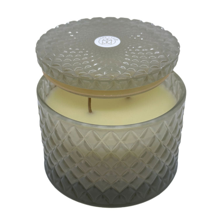 Vanilla Sandalwood decorative candle by SAND + FOG in a textured glass jar with a lid on a white background