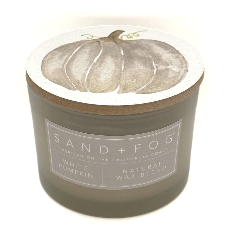 Green candle with a label for 'White Pumpkin' by Sand + Fog on a white background