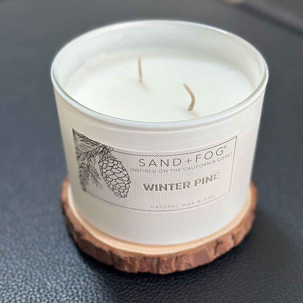 Winter Pine Scented Candle on a wood lid by SAND + FOG