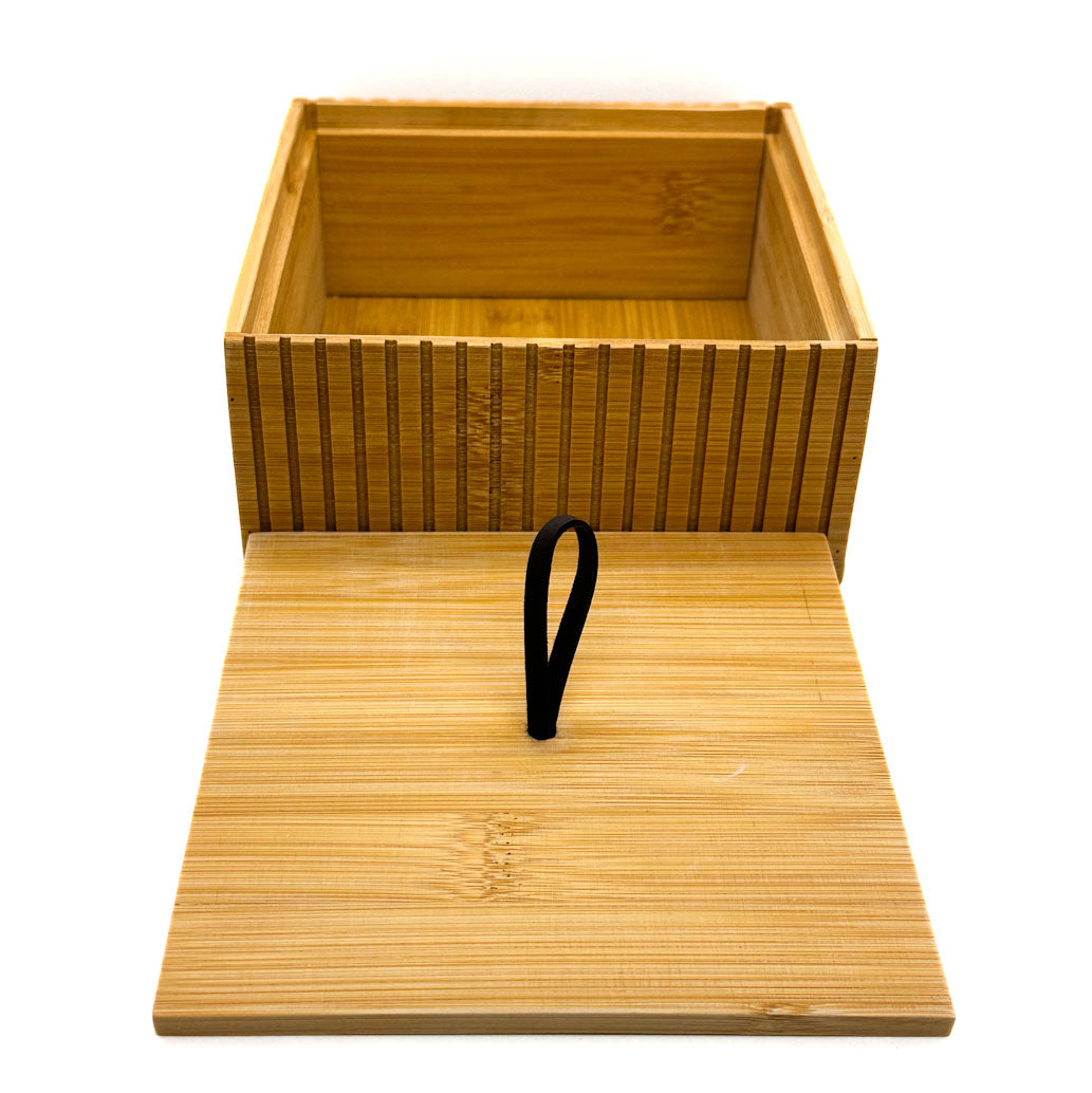 Bamboo box with lid and black handle on a white background