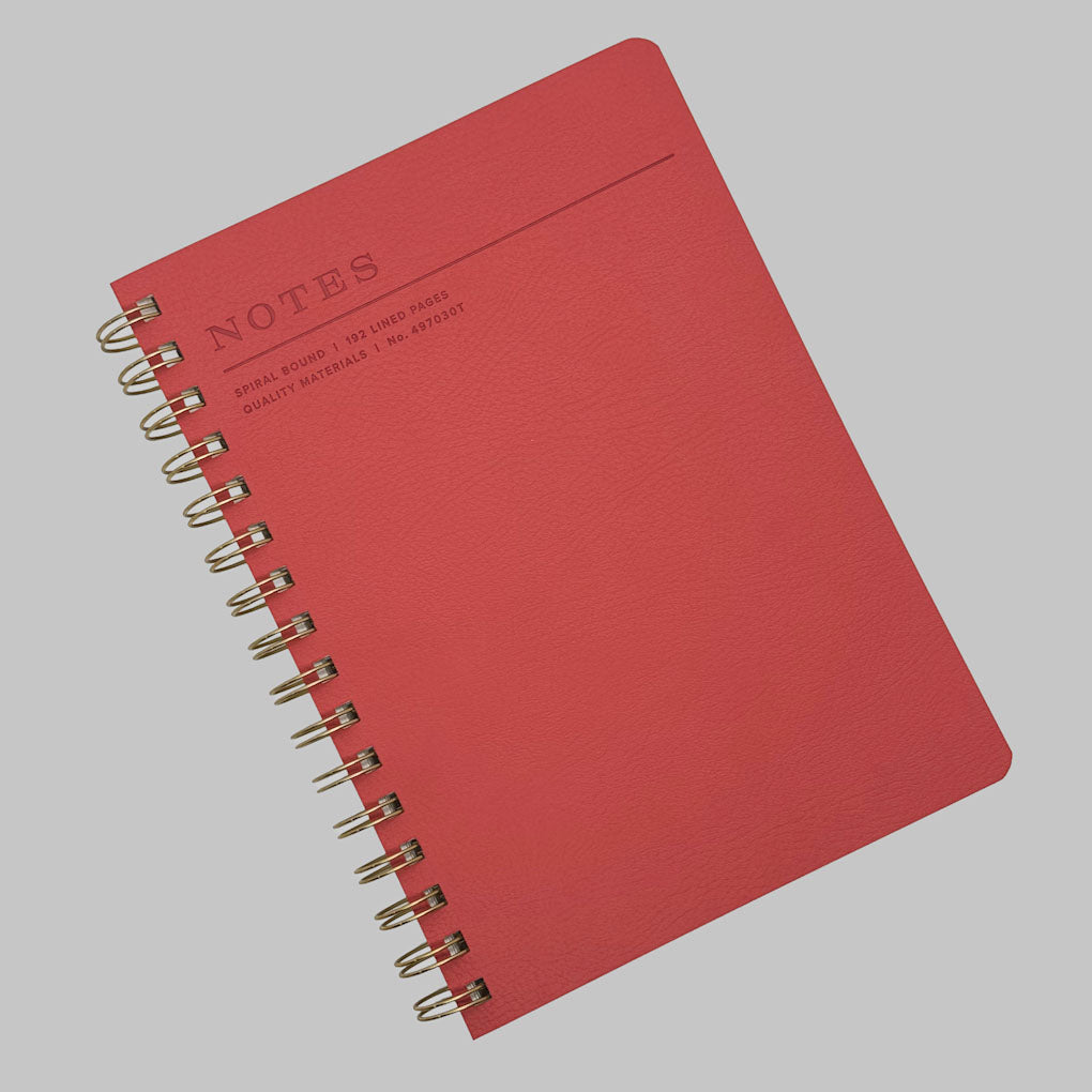 Fringe Studio Tangerine notebook with spiral binding on a grey background