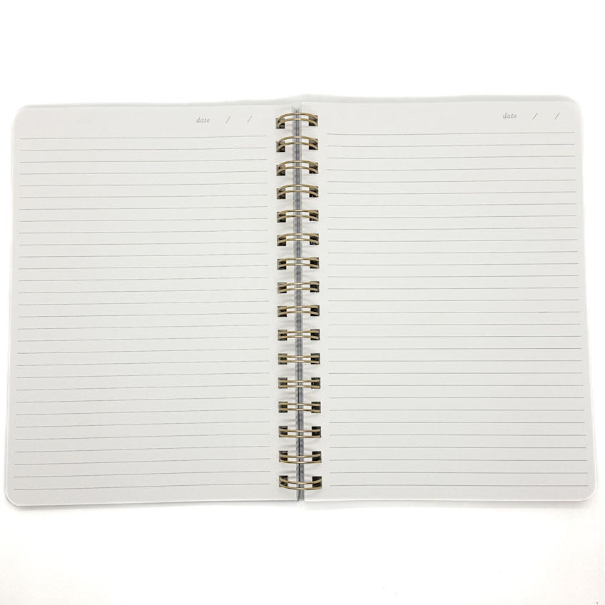 An open spiral-bound lined notebook with white pages and a silver metal coil binding, photographed on a plain white background.