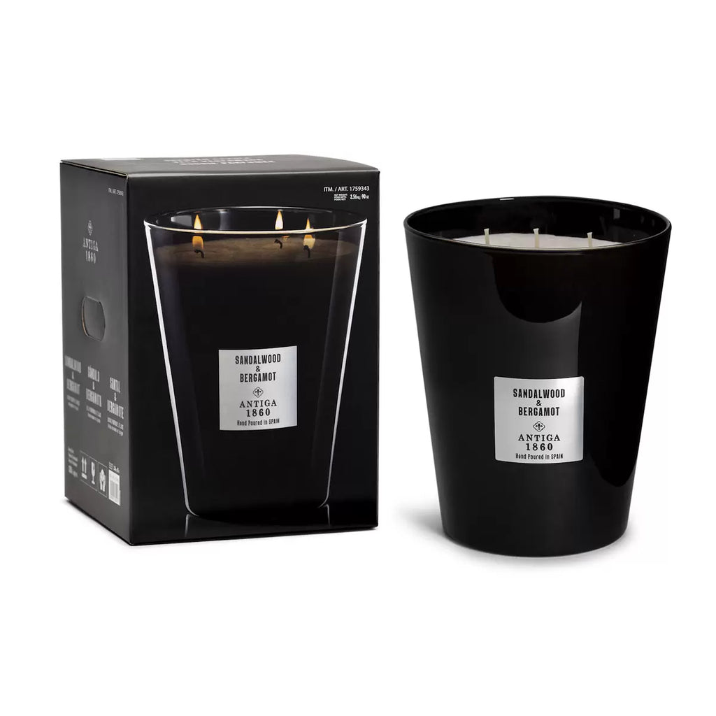 Antiga 1860 Sandalwood & Bergamot black candle with a label next to its packaging on a white background