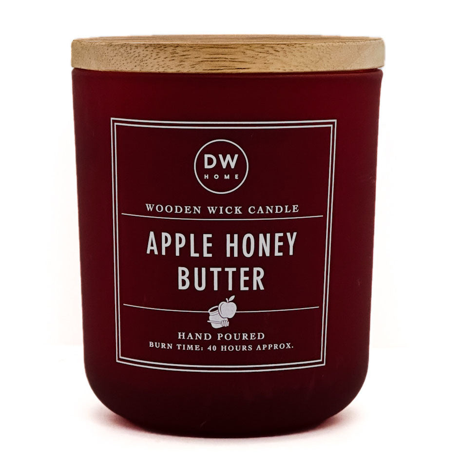 A dark red glass candle jar with a light wood lid, featuring a white label that reads 'DW HOME' and 'APPLE HONEY BUTTER'.