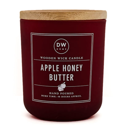 A dark red glass candle jar with a light wood lid, featuring a white label that reads 'DW HOME' and 'APPLE HONEY BUTTER'.