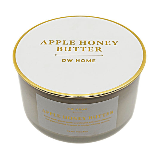 A round jar candle with a white lid and a white front label, both printed with gold text reading 'APPLE HONEY BUTTER' and 'DW HOME'. The candle is photographed on a clean white background.