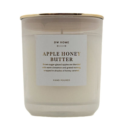 A single-wick candle in a frosted glass jar with a white label reading 'DW HOME APPLE HONEY BUTTER' and a gold metal lid, shown on a white background.