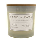 Black Currant candle with 'Sand + Paws' label on a white background