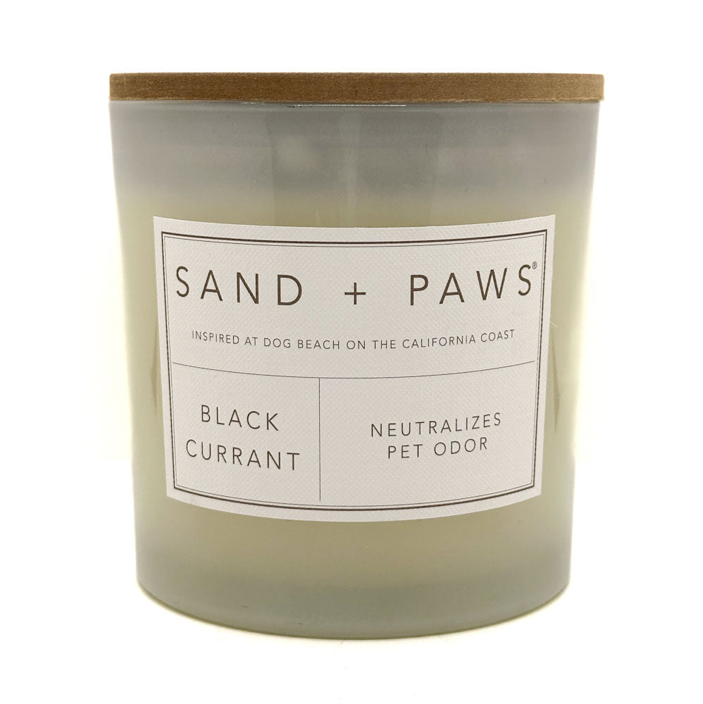 Black Currant candle with 'Sand + Paws' label on a white background