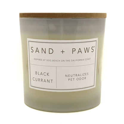 Black Currant candle with 'Sand + Paws' label on a white background