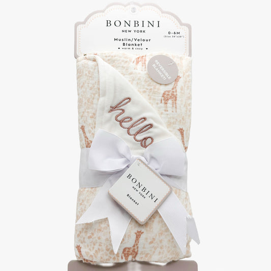 Bonbini New York muslin/velour baby blanket in cream with a light brown giraffe print, wrapped in a white ribbon with a bow and 'hello' embroidered on the corner, shown in its retail packaging.