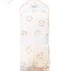 A folded muslin/velvet baby blanket with a cute teddy bear face pattern, packaged in its original retail card packaging with a white paper band around the middle.