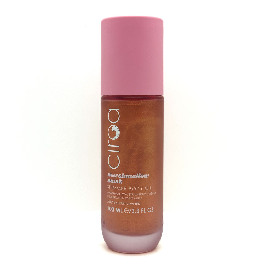 A bottle of Ciroa Marshmallow Musk Shimmer Body Oil, featuring a pink cap and a brown translucent bottle showing the shimmering oil inside, set against a plain white background.