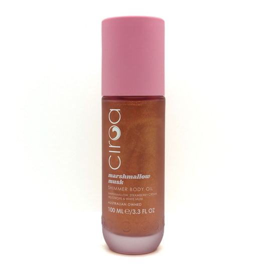 A bottle of Ciroa Marshmallow Musk Shimmer Body Oil, featuring a pink cap and a brown translucent bottle showing the shimmering oil inside, set against a plain white background.