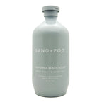 A 32 fl oz matte light gray bottle of Sand + Fog California Beach House body wash shower gel on a white background.