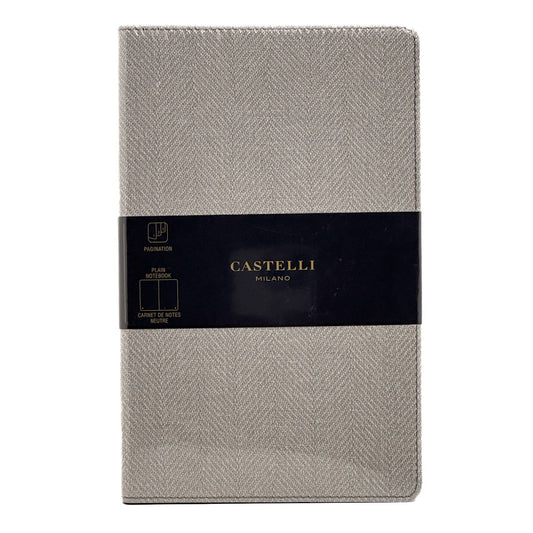 A single Castelli Milano planner cover in a light grey herringbone fabric, wrapped with a black paper band featuring the brand name in gold.
