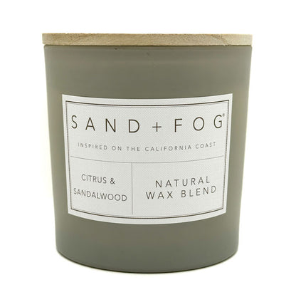 Citrus & Sandalwood scented candle with 'Sand + Fog' label on a white background