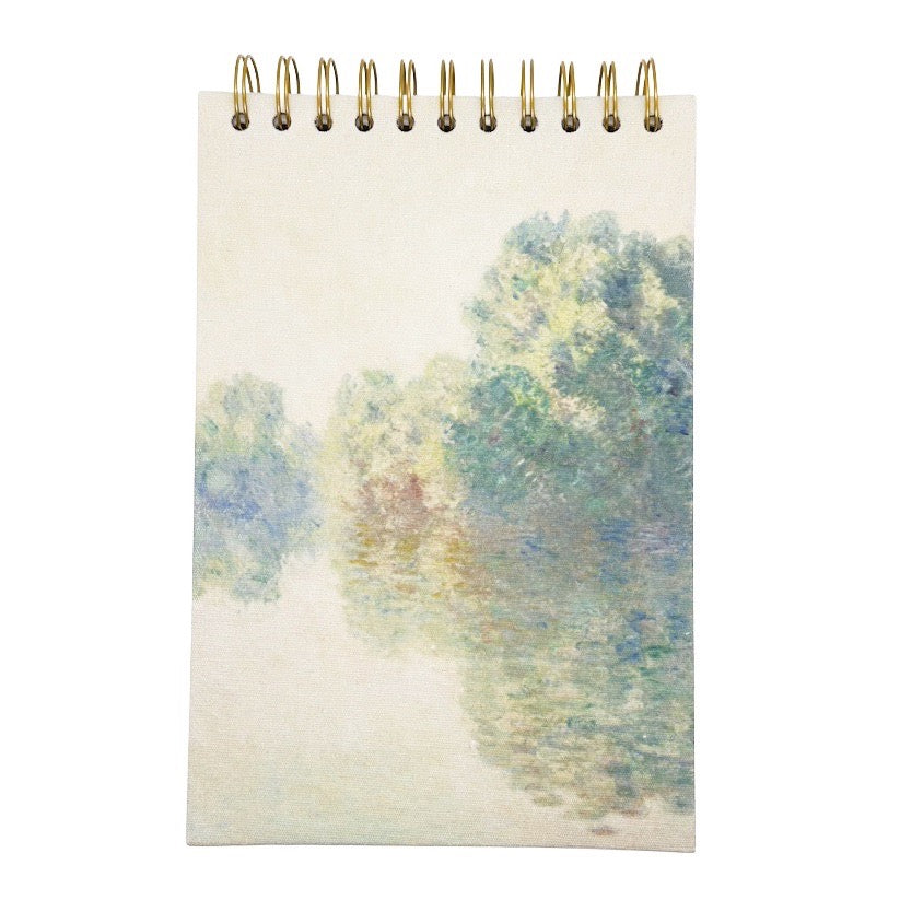 Sketchbook with a spiral binding featuring a watercolour design of trees and a path on the cover.