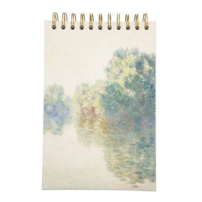 Sketchbook with a spiral binding featuring a watercolour design of trees and a path on the cover.