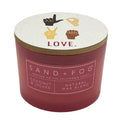 Red candle with a white lid featuring hand signs and 'LOVE.' text, branded as Sand + Fog.