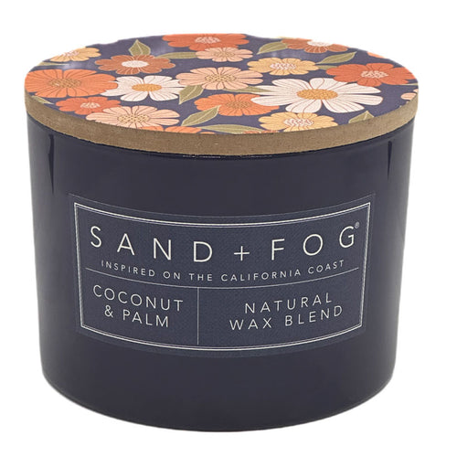 Coconut & Palm candle with floral lid and 'Sand + Fog' label on a white background